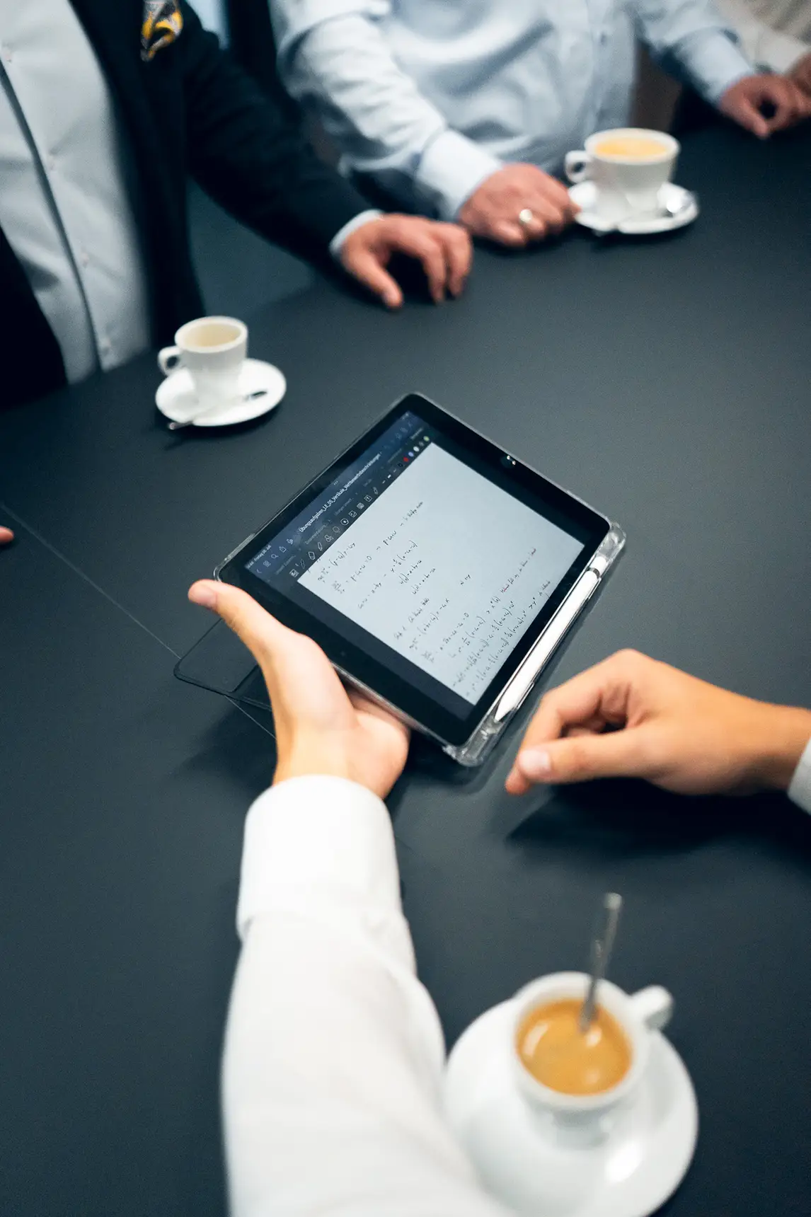 Teammitglied hält ein Tablet mit Notizen während eines Meetings bei awi consulting.